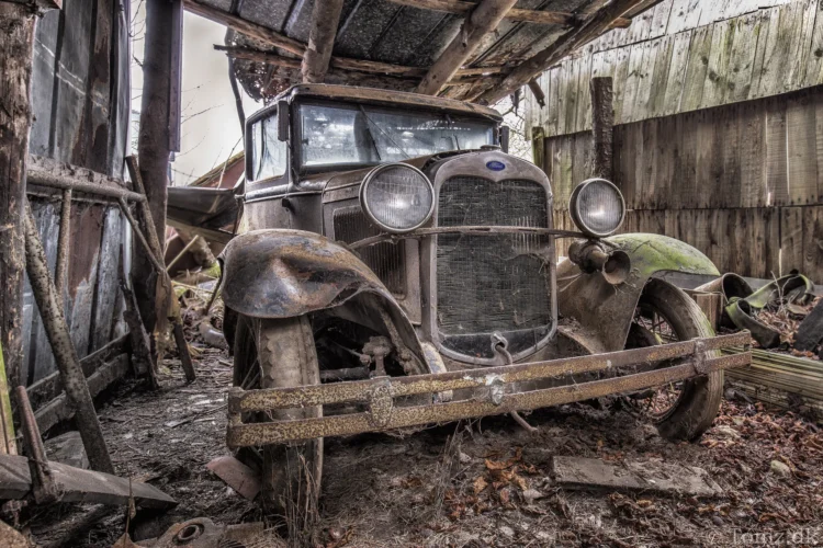 Gammel Ford i forfald med rust og slidte detaljer
